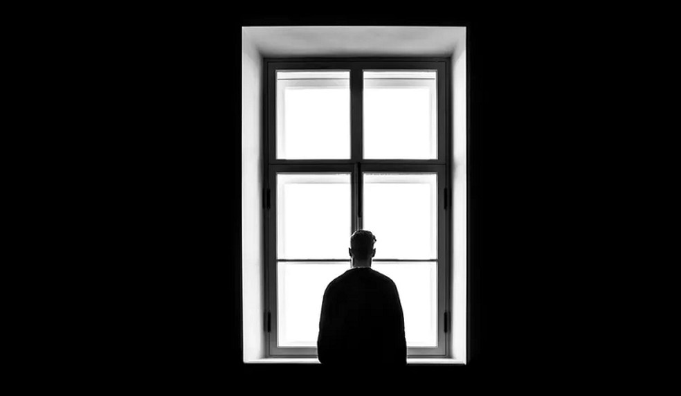 Ilustração de uma pessoa em pé em frente a uma janela fechada — Foto: G1