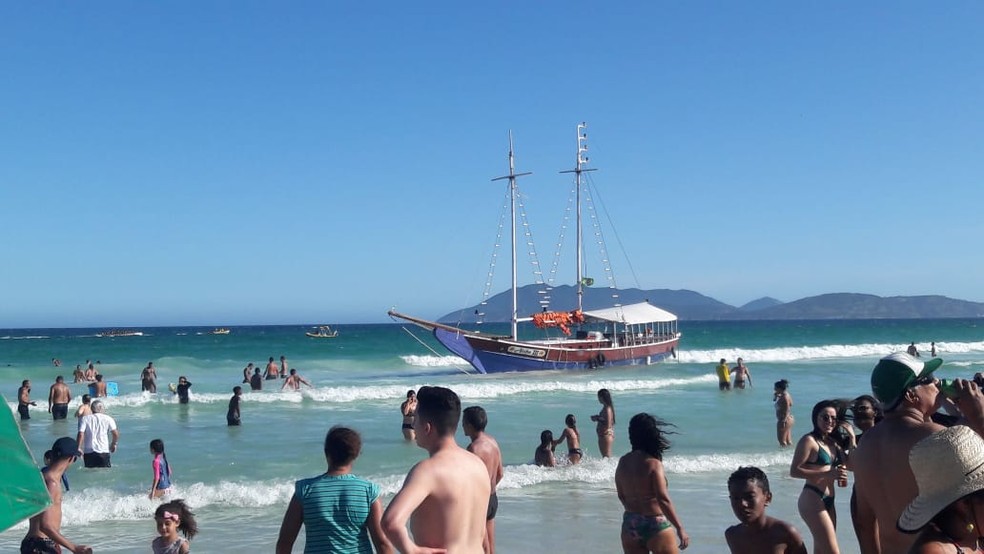 Barco encalhou na areia da praia, em Cabo Frio. Banhistas estavam na água durante o ocorrido. — Foto: Roberta Camargo/G1