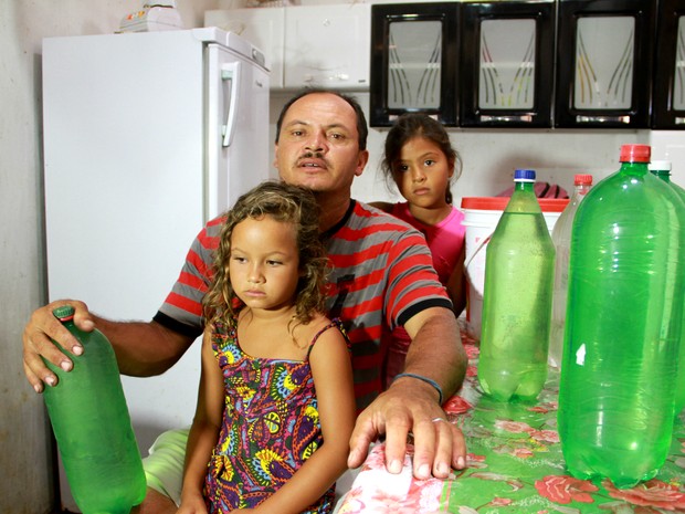 O pescador Jorge Souza mostra garrafas de água doce que armazena para o consumo da família (Foto: Waldson Costa/G1)