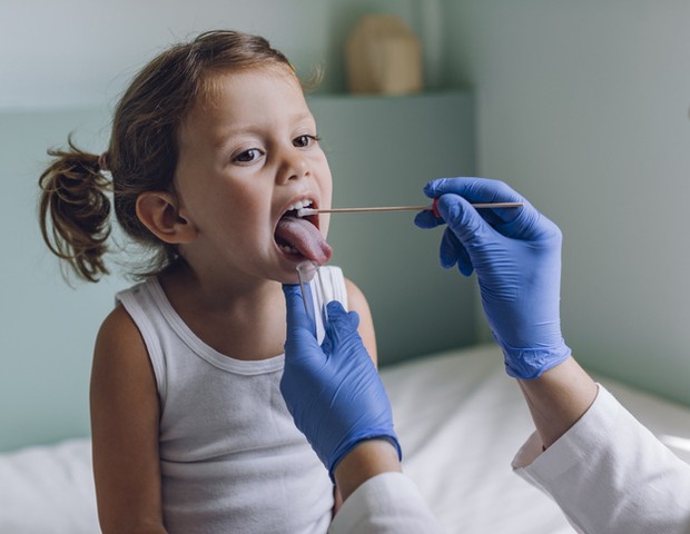 Nurse performing a mouth swab test on a little child. (Foto: Getty Images)
