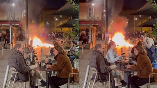 Clientes de restaurante ignoram fogo durante protesto e continuam sentados como se nada acontecesse
