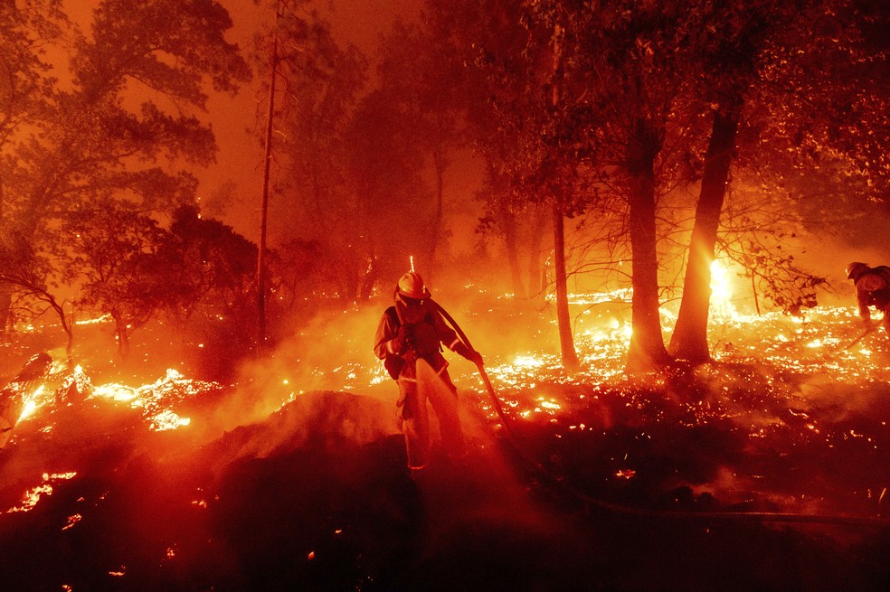 Bombeiro luta contra as chamas no Condado de Madera, na Califórnia, nesta segunda-feira (7). — Foto: Noah Berger / AP Photo