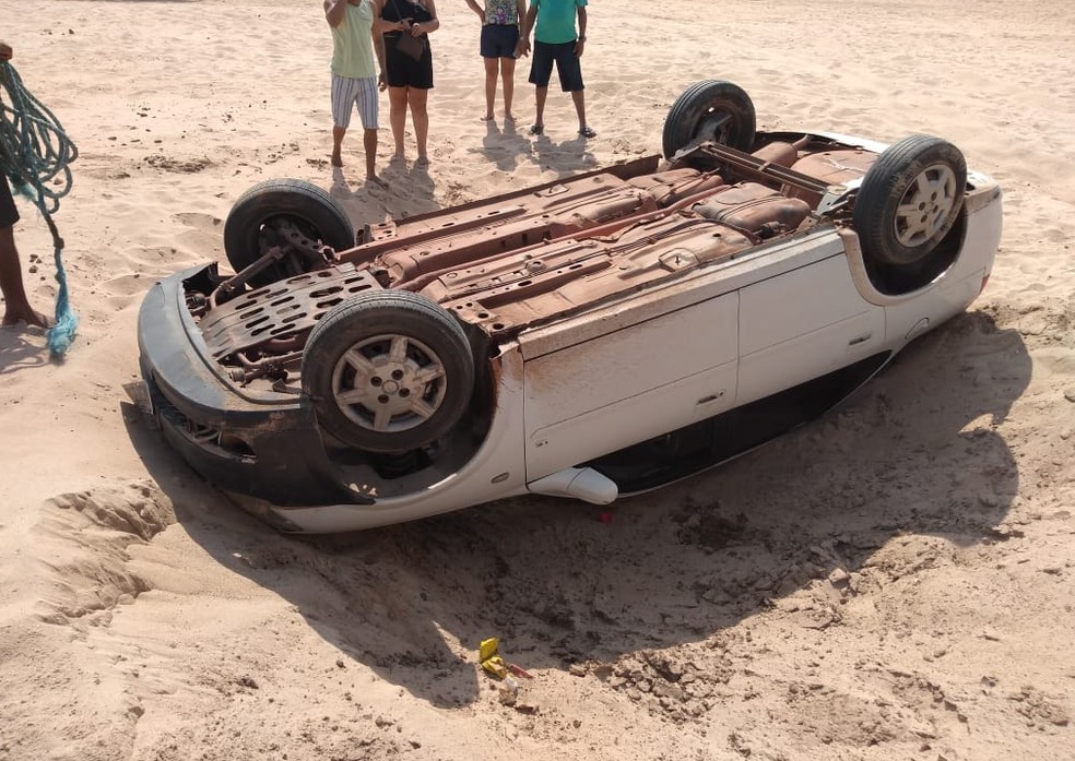 Carro capotou após motorista tentar fazer manobra na faixa de areia, o que é proibido por lei — Foto: Reprodução/Redes Sociais