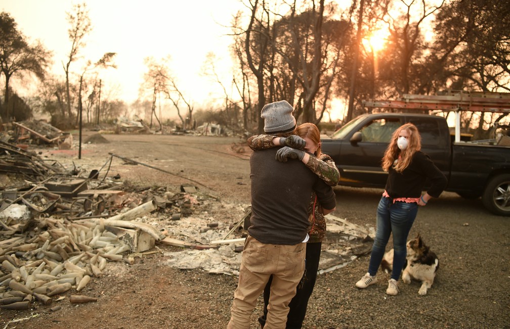 Família se emociona neste domingo (18) ao voltar ao local de sua casa e vê-la queimada por incêndio Camp Fire em Paradise, na Califórnia — Foto: Josh Edelson / AFP