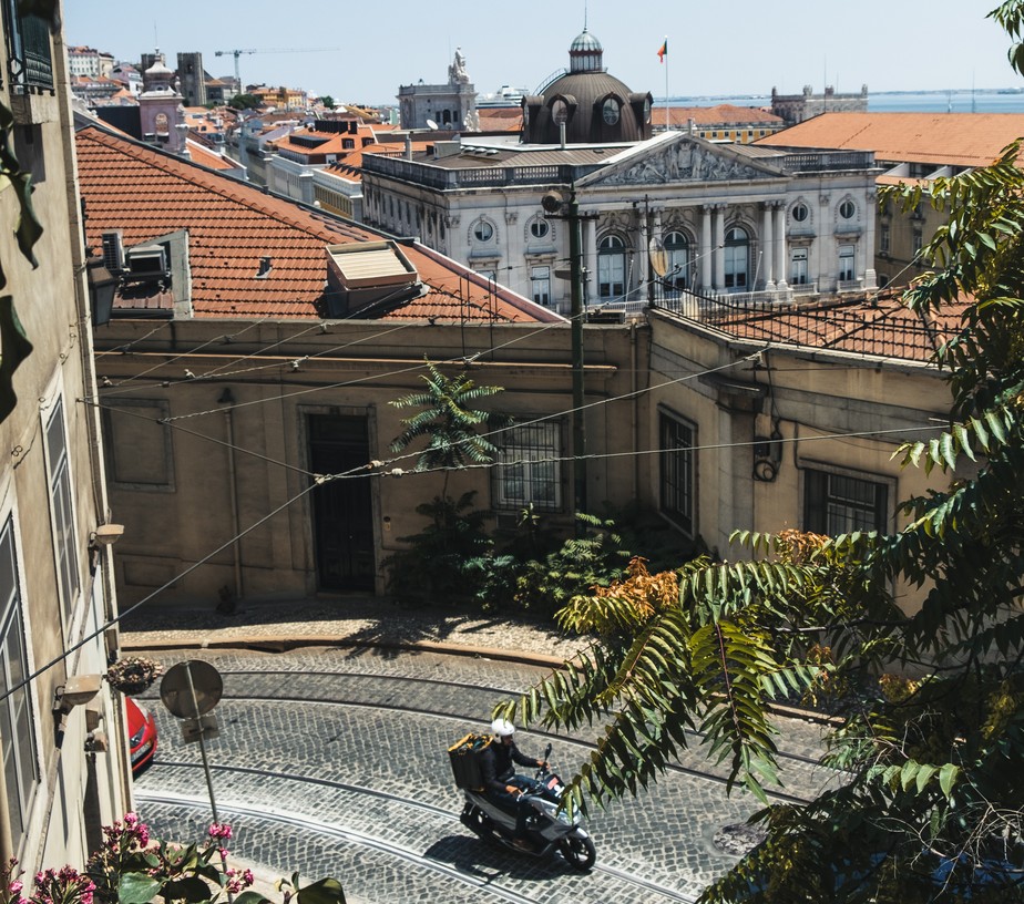 Motoboy circula por rua de Lisboa