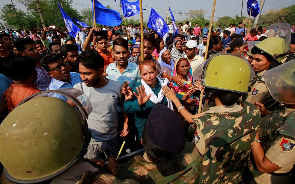 PolÃ­cia contÃ©m manifestantes que protestavam contra suspensÃ£o de lei que previa prisÃ£o para agressores de pessoas de castas inferiores  (Foto: Ajay Verma/ Reuters)