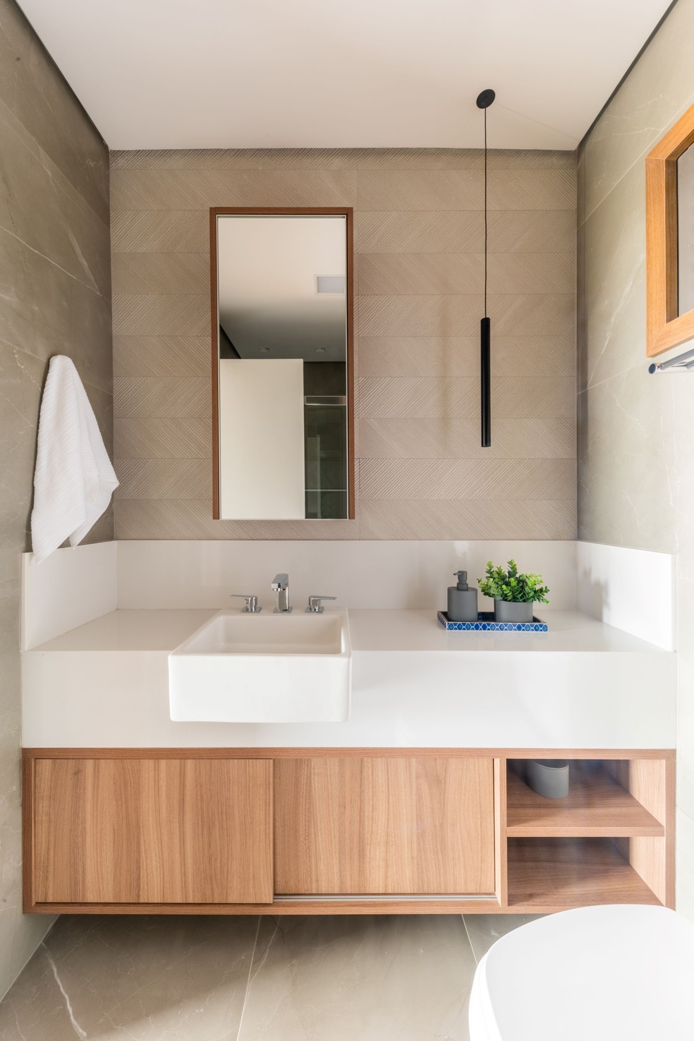DÚPLEX DE RAFAEL: No lavabo do irmão, os acabamentos mais neutros, com tonalidades off-white e aspecto mais clássico — Foto: Guilherme Pucci