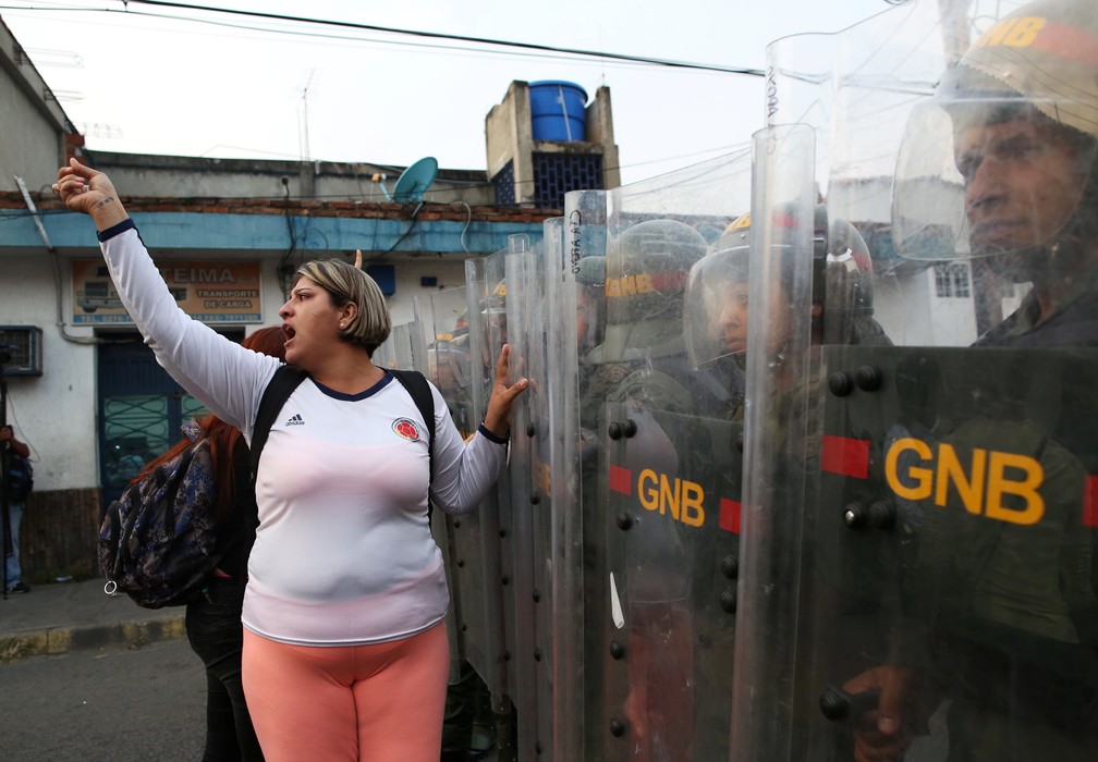 Mulher protesta as forças de segurança em Ureña, Venezuela, neste sábado (23), na fronteira com a Colômbia. — Foto: REUTERS/Andres Martinez Casares