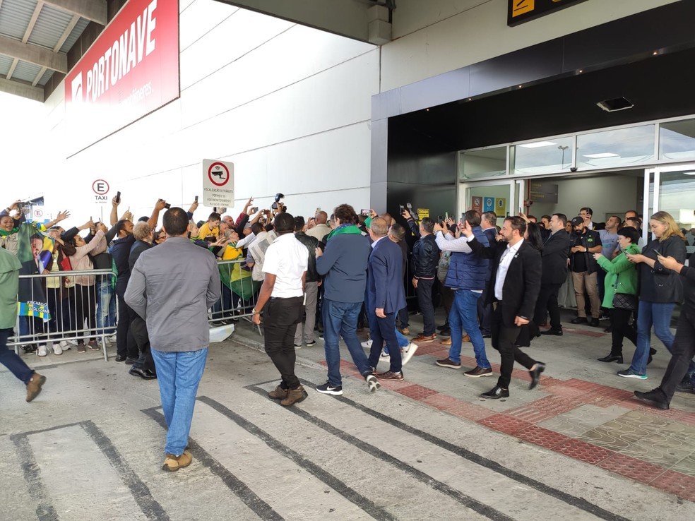 Bolsonaro &eacute; cumprimentado por apoiadores no aeroporto de Navegantes &mdash; Foto: Ana Cristina Machado/NSC TV