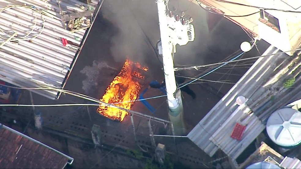 PM aparece jogando móveis ao fogo no Dona Marta — Foto: Reprodução/TV Globo