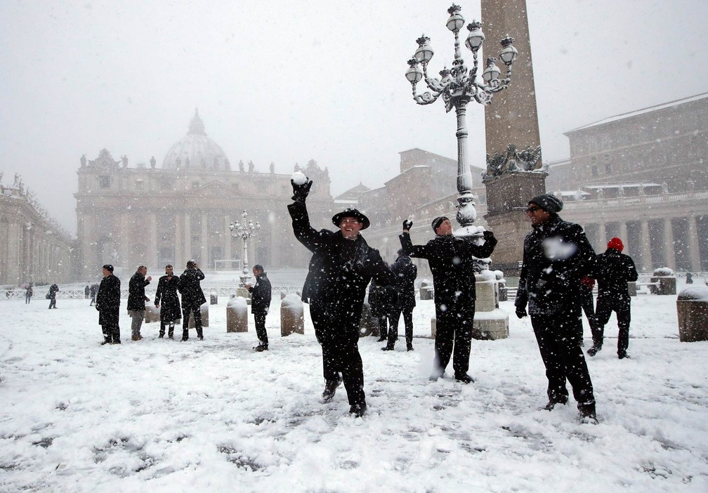 Jovens padres se divertem atirando bolas de neve na Praça de São Pedro, no Vaticano (Foto: Alessandra Tarantino/AP)