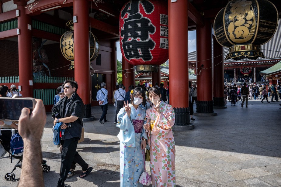 Mulheres posam para foto no templo Sensoji, uma popular atração em Tóquio: Japão acaba de derrubar exigência de comprovante de vacinação e teste contra Covid para viajantes internacionais