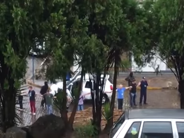 Reféns formaram cordão humano em torno de carro de assaltantes em Putinga, RS (Foto: Reprodução/YouTube.com)