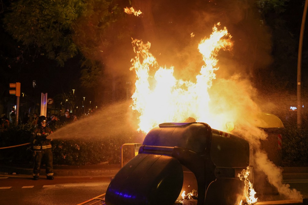 Bombeiros apagam fogo em lixeira durante terceira noite de protestos em Barcelona, em 18 de fevereiro de 2021 — Foto: Nacho Doce/Reuters