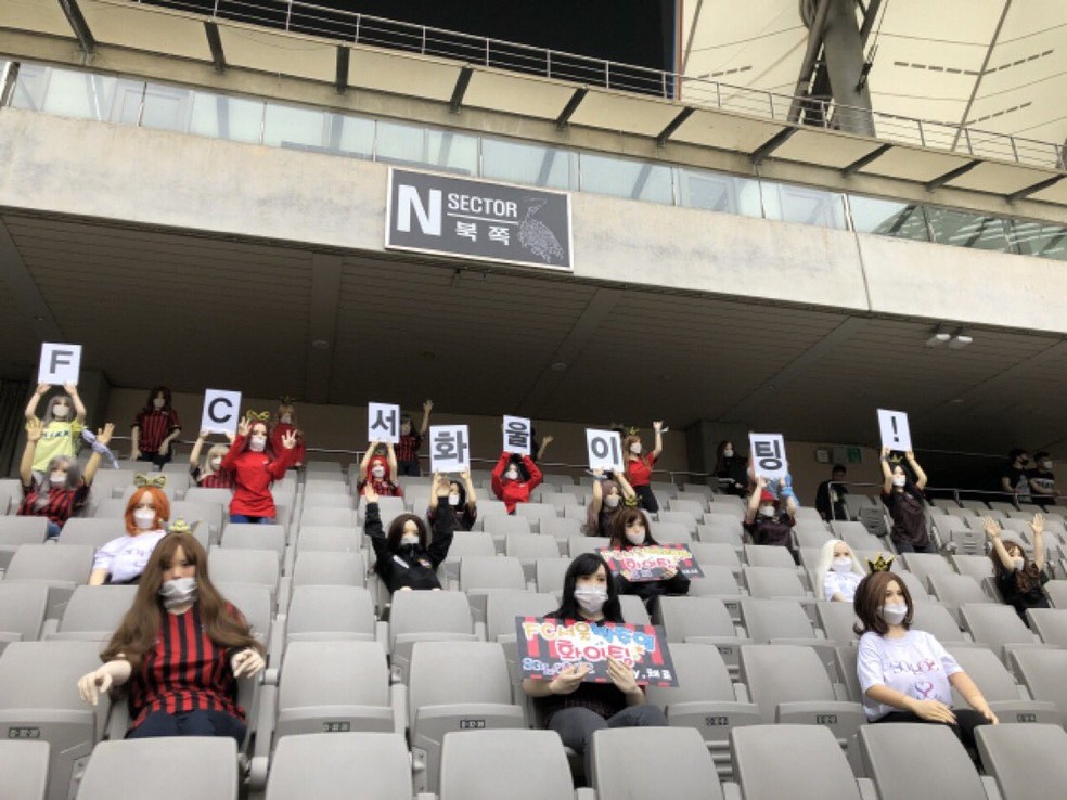 Bonecas de torcedoras com cartazes na arquibancada em jogo do FC Seoul, na Coreia do Sul — Foto: Reprodução