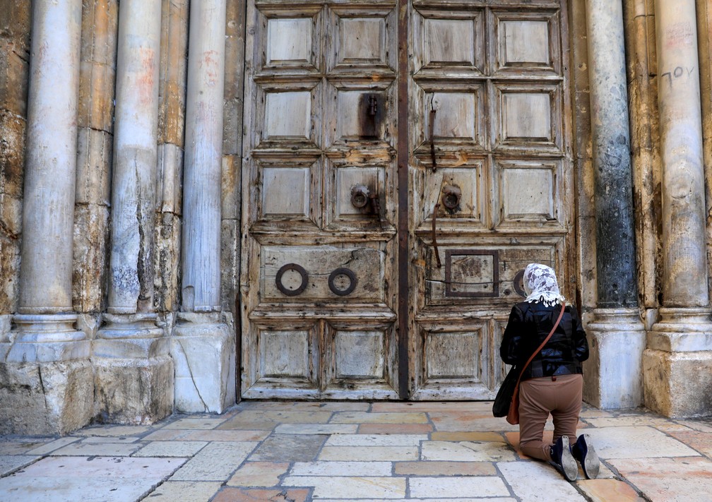 Cristão em frente à Igreja do Santo Sepulcro, em Israel, antes do início do culto de domingo de Páscoa — Foto: Emmanuel Dunand / AFP Photo