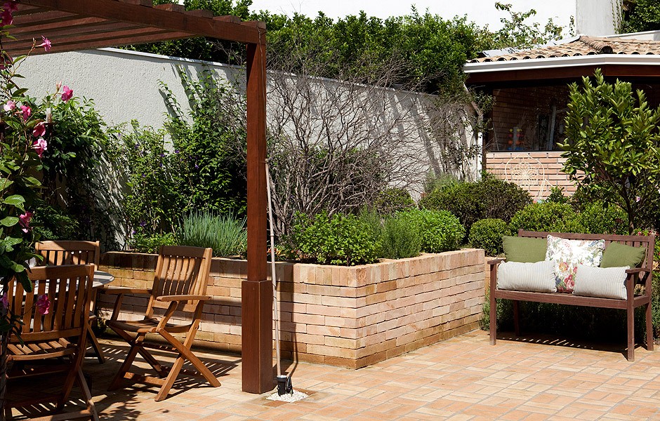 Além de pérgola sobre a mesa e banco para relaxar, este quintal dos sonhos tem uma horta. Projeto assinado pela paisagista Cláudia Munõz (Foto: Edu Castello/Editora Globo)