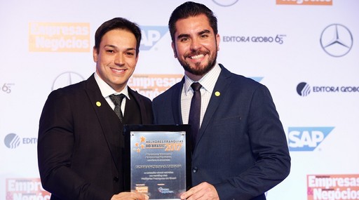 Alisson Ramallho, da Sobrancelhas Design, recebe o prêmio de Ciro Hashimoto, da Editora Globo