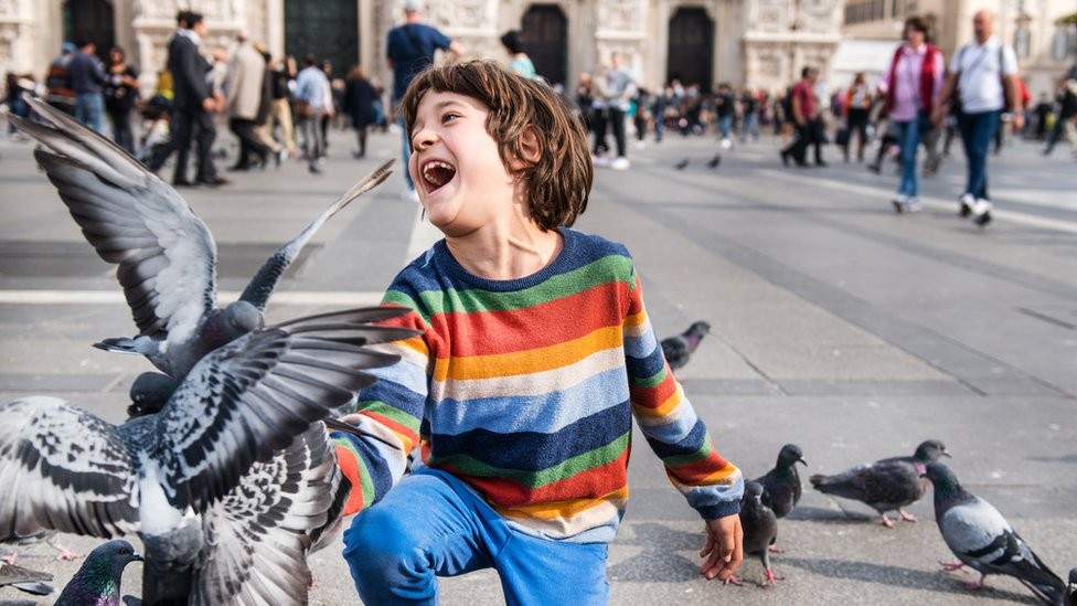 As crianças estão entre os poucos que gostam de brincar com pombos, já que para a maioria dos adultos estas aves são uma praga (Foto: Getty Images via BBC)