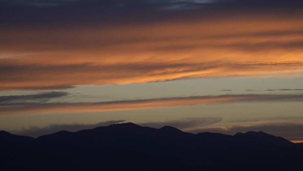 O sol poente ilumina as nuvens sobre as Montanhas Rochosas de Denver, no Colorado, EUA (22/06/22). — Foto: AP Photo/David Zalubowski