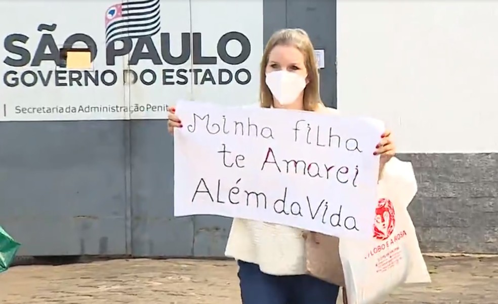 Elize Matsunaga exibe cartaz na saída de presídio — Foto: André Bias/TV Vanguarda