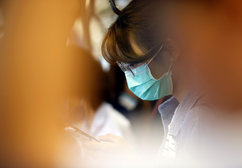 Mulher se protege com máscara como medida de prevenção contra o coronavírus — Foto: Soe Zeya Tun/Reuters
