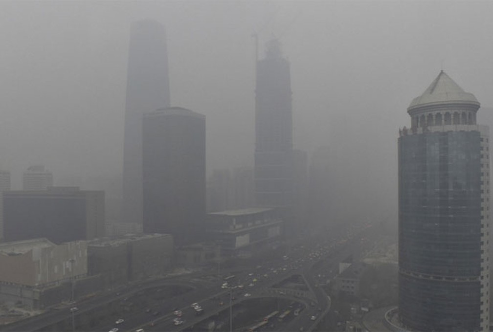 Nuvens de fumaça de poluição são vistas perto da ponte Guomao, na área comercial de Pequim, na China (Foto: Reuters)