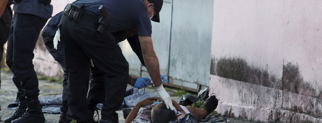 Policiais fazem perícia em corpo de vítima de operação policial na Vila da Penha, Zona Norte do Rio — Foto: Fabiano Rocha / Agência O Globo