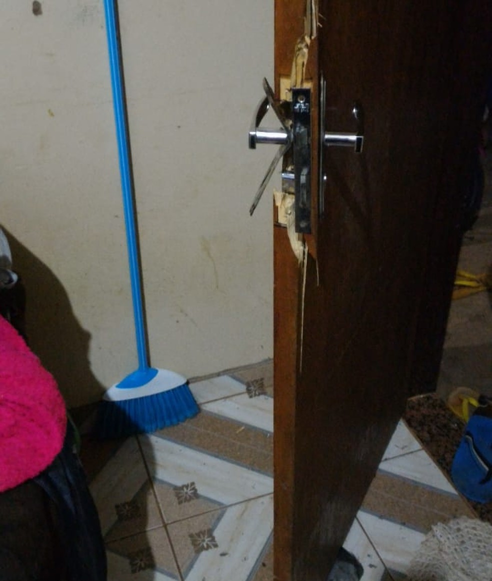 Porta arrombada pela polícia para salvar mãe e filhos  (Foto: PM/Divulgação)