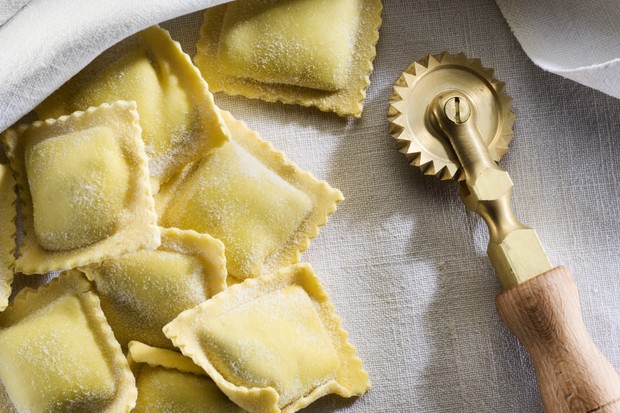 Some fresh ravioli on a linen cloth with a brass cutter for pasta. (Foto: Getty Images)
