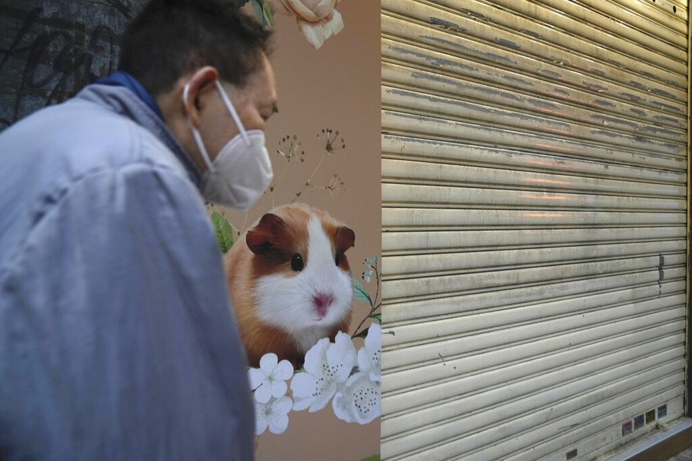 Homem passa em frente a pet shop fechado em Hong Kong em 18 de janeiro de 2022 — Foto: AP Photo/Kin Cheung