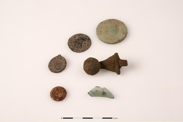 Ficha, moedas, fecho de metal e pequeno fragmento de vidro antigo