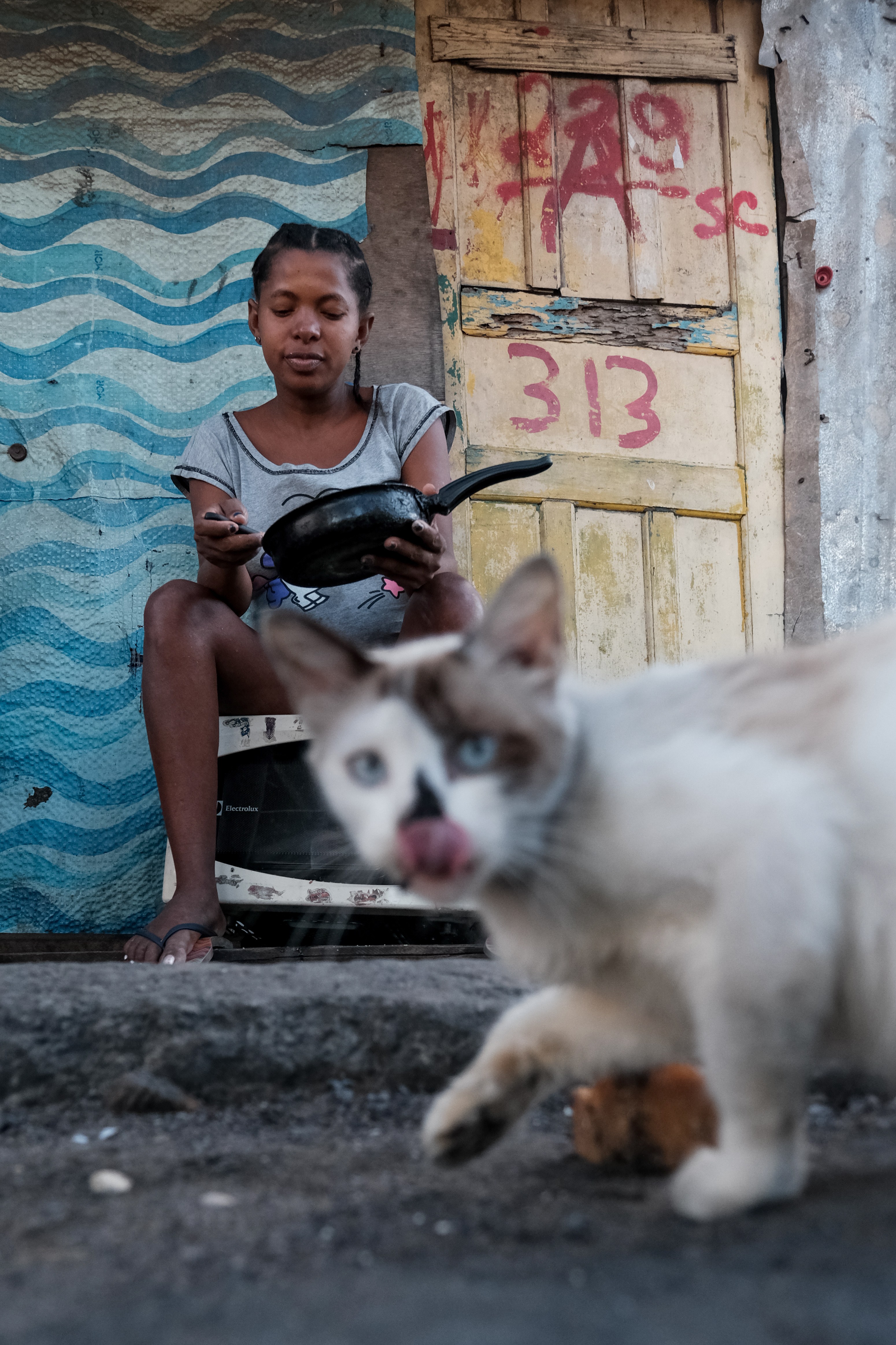 Laudeci Sales dos Santos, 32, grávida de sete meses, faz uma refeição de linguiça com farinha que ganhou do vizinho. Laudeci é mãe solo de uma criança de 8 anos (Foto: Felipe Nyland / Getty Images)