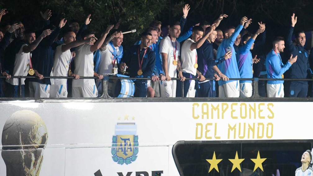 Jogadores da seleção argentina acenam do ônibus  — Foto:  Gustavo Garello / AP Photo