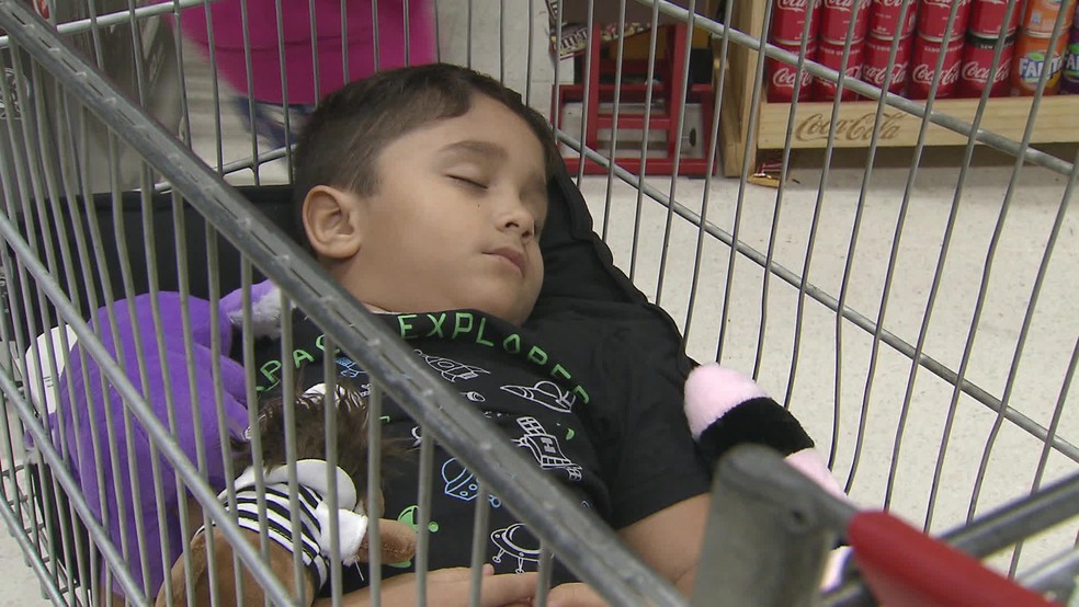 Yuri dorme em carrinho de supermercado enquanto o pai, André Tavares, faz compras de madrugada  — Foto: Reprodução/TV Globo 