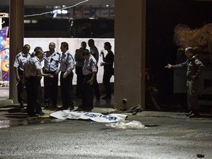 Polícia israelense ao lado de corpo de palestino após ataque a estação em Beersheba (Foto: Tsafrir Abayov/AP)