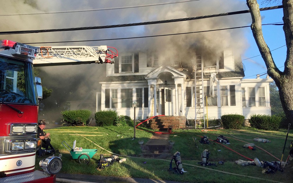 Bombeiros combatem incêndio em uma casa na Herrick Road em North Andover, Massachusetts, na quinta-feira (13) — Foto: AP Photo/Mary Schwalm