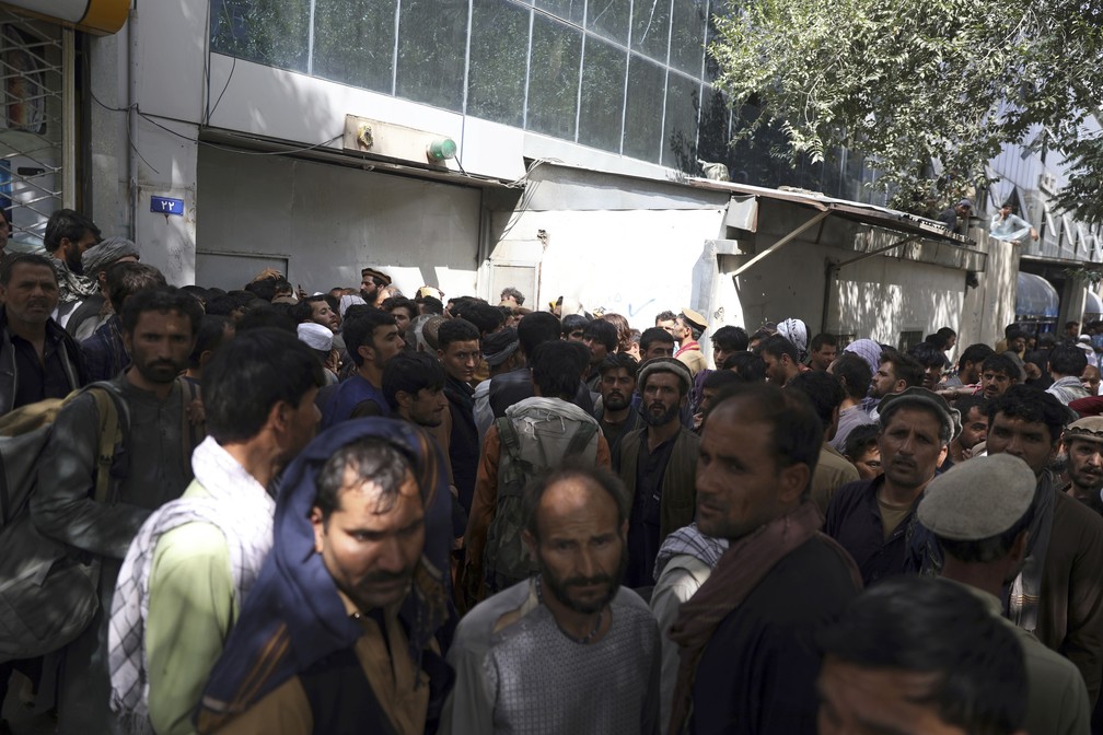 Pepolação afegã espera por horas em filas para tentar sacar dinheiro na frente do Banco de Cabul. — Foto: ASSOCIATED PRESS