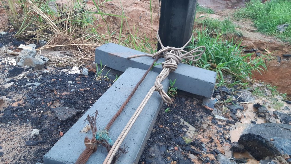 Após chuva, moradores do bairro de Coutos amarram poste pra evitar queda de equipamento em Salvador — Foto: Rafael Alves/TV Bahia