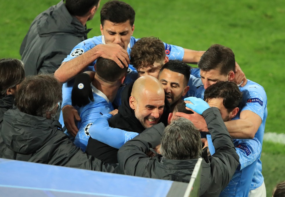 Guardiola é abraçado pelos jogadores do Manchester City em uma das vitórias do clube na temporada — Foto: Reuters