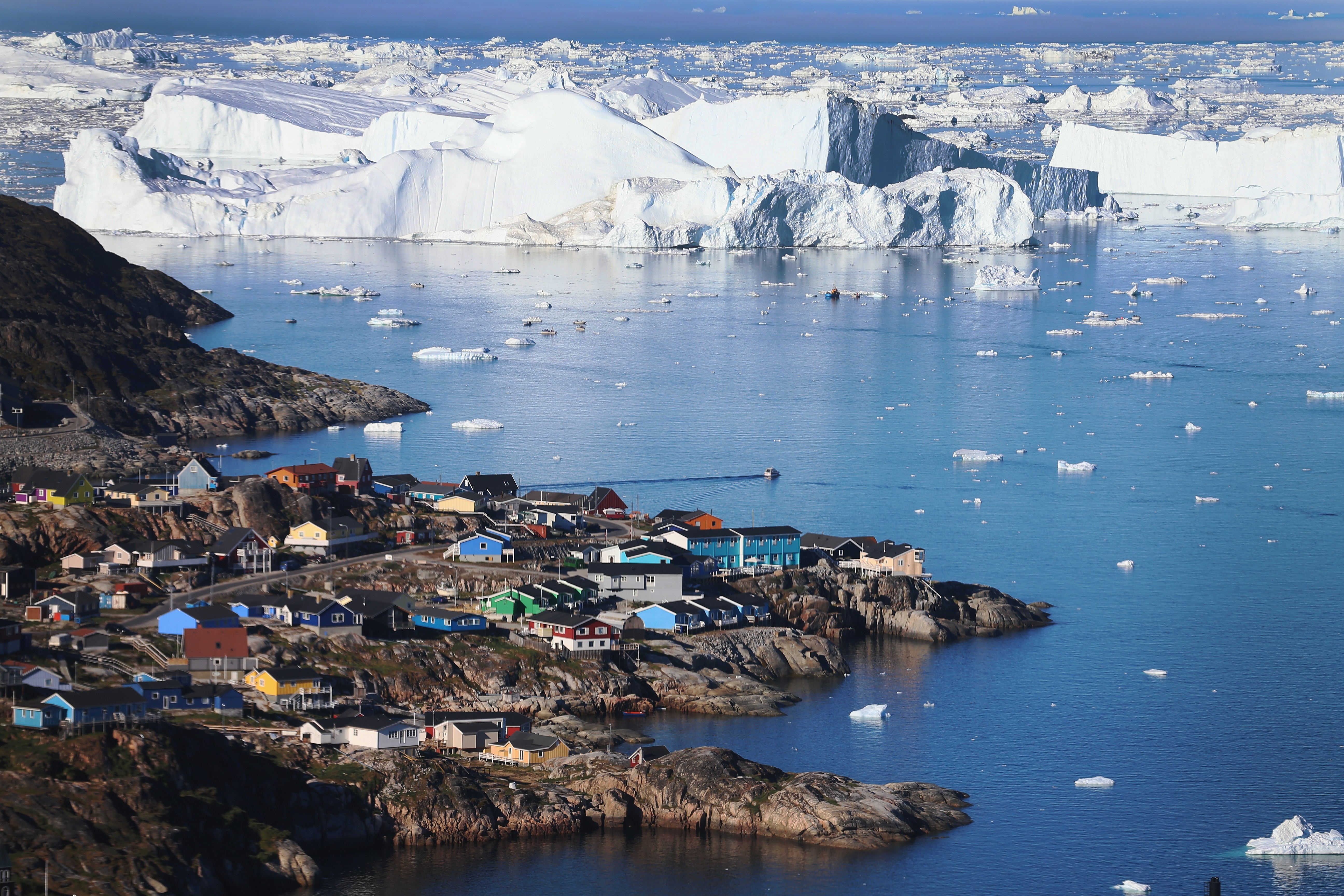 Vila de Ilulissat ao lado de icebergs que se desprenderam da geleria Jakobshavn (Foto: Getty Images)