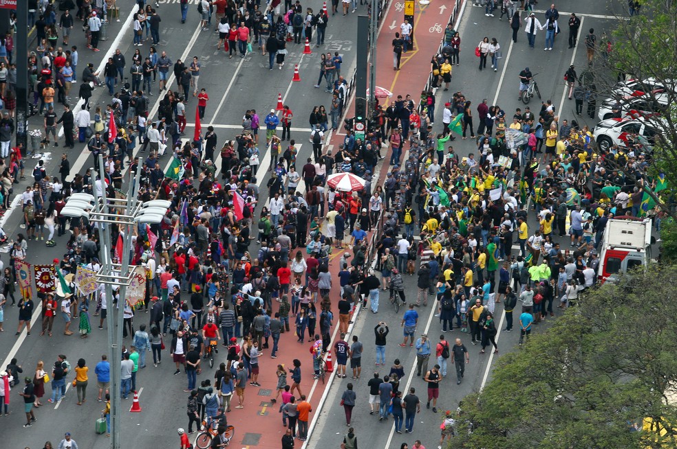 Apoiadores de Haddad, à esquerda, e de Bolsonaro, à direita, durante protestos neste domingo (14), na Avenida Paulista, em São Paulo — Foto: Reuters / Amanda Perobelli