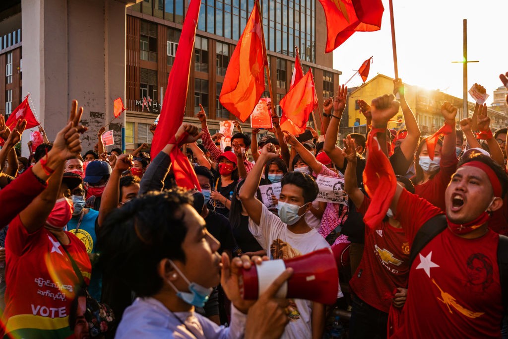 YANGON, MYANMAR - FEBRUARY 07: Protesters shout slogans while carrying red flags on February 07, 2021 in downtown Yangon, Myanmar. Some internet services were restored in Myanmar on Sunday, almost a week after a military coup in which de-facto leader Aung (Foto: Getty Images)