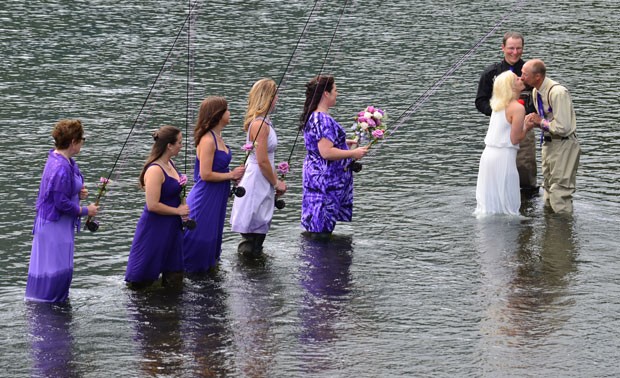Acompanhado pelos padrinhos, um casal inovou no último sábado (3) e se casou no rio Buskin enquanto todos pescavam em Kodiak (Foto: James Brooks/Kodiak Daily Mirror/AP)