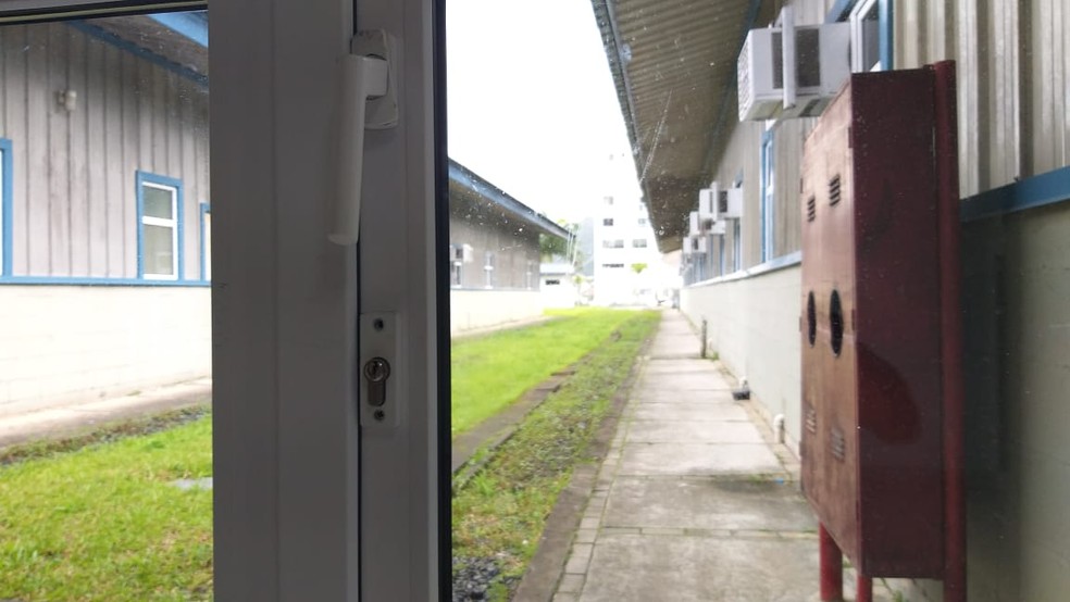 Porta lateral do acesso de emergência estava arrombada segundo a polícia — Foto: Luis Souza/ NSC TV