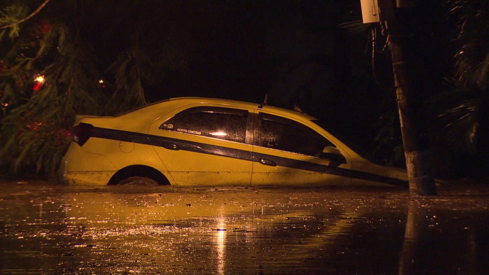 Táxi é visto boiando em bolsão d'água (Foto: Reprodução / Tv Globo)