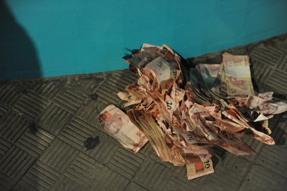 Dinheiro deixado por criminosos que assaltaram banco em Criciúma — Foto: Caio Marcello/Agif - Agência de Fotografia/Estadão Conteúdo