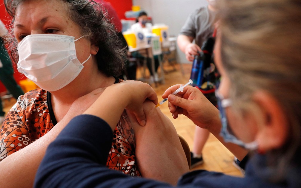 Mulher recebe dose de vacina contra Covid em Santiago, no Chile, na quinta-feira (23) — Foto: Javier Torres/AFP