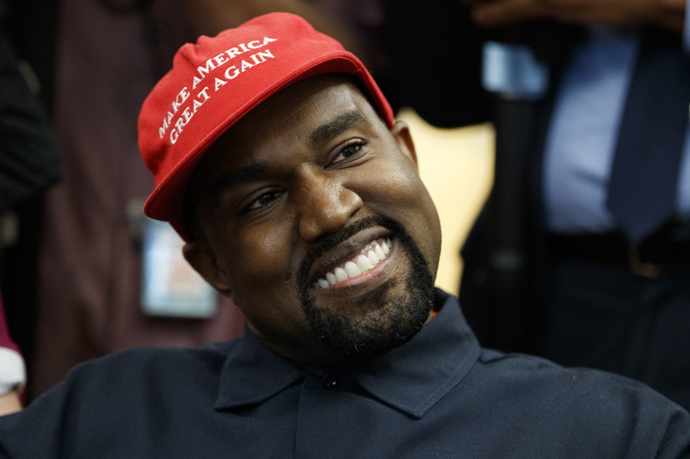 Kanye West usa boné com frase símbolo da campanha de Trump durante encontro com presidente dos EUA no Salão Oval da Casa Branca — Foto: AP Photo/Evan Vucci