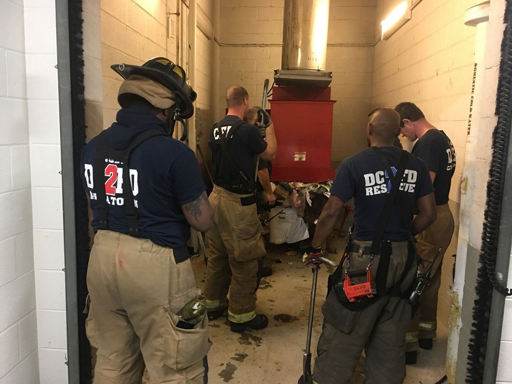Bombeiros resgatam homem que caiu no lixo ao procurar celular perdido nos EUA (Foto: Vito Maggiolo/DC Fire and EMS Department via AP)